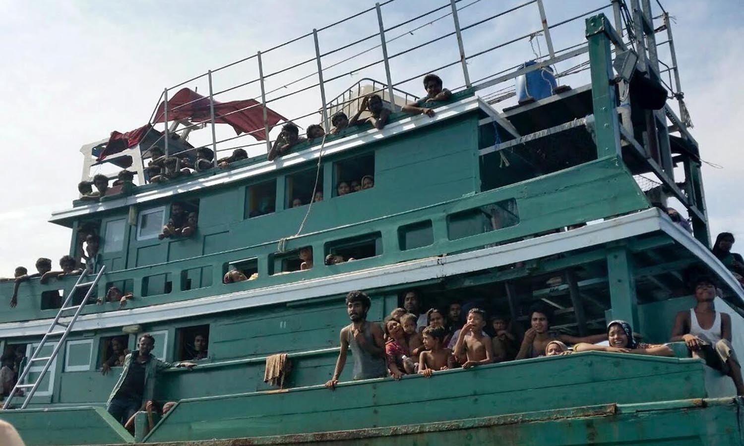 Migrants who arrived in Indonesia by boat eat inside a temporary shelter — Reuters